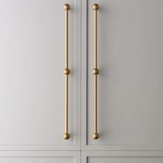 an image of a door handle on the front of a white cabinet with gold knobs