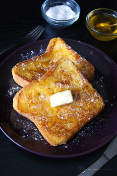 two pieces of french toast on a plate with butter