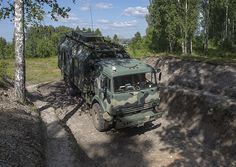 an army truck driving down a dirt road