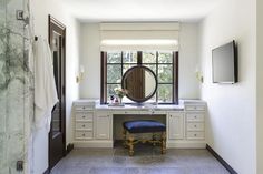 a room with a desk, mirror and window