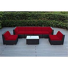 an outdoor patio furniture set with red cushions and coffee table on a wooden deck surrounded by hedges