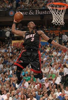 a man dunking a basketball in front of an audience