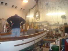 a man standing on top of a boat in a shop