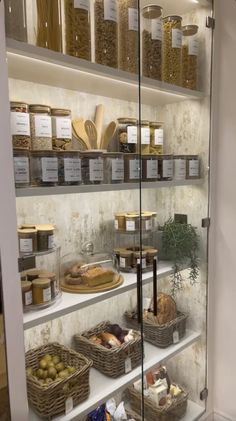 an open glass door with food in baskets on it and shelves full of breads