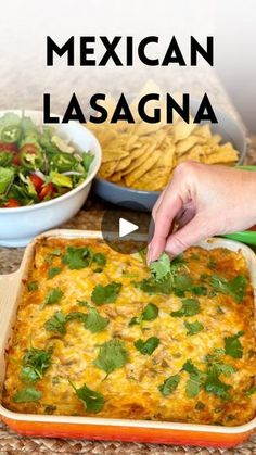 mexican lasagna in a casserole dish with tortilla chips on the side