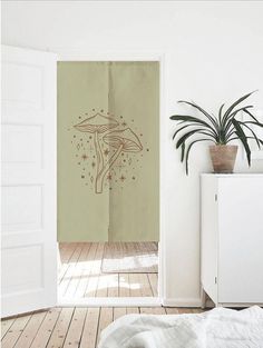 an open door leading to a bedroom with a plant in the corner and a wall hanging