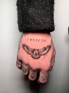 a person's hand with a tattoo on it and the words invicto