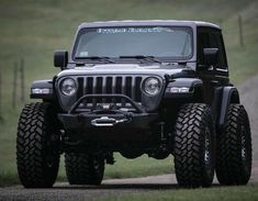 a black jeep driving down a dirt road