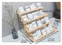 three tiered wooden display stand with cards and earrings on each shelf, measurements for each card