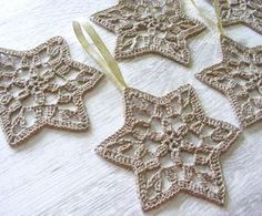 four crocheted ornaments are hanging on a table