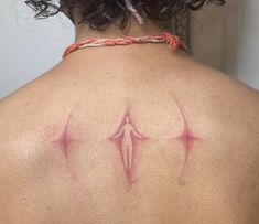 the back of a woman's shoulder with red ink on her upper arm and chest