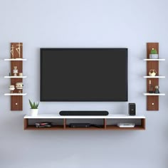 a flat screen tv mounted to the side of a wall next to bookshelves