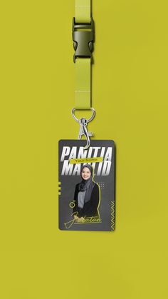 a keychain hanging from the side of a yellow wall with an image of a woman on it