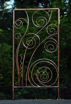 an iron gate in front of some trees