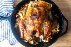 a roasted chicken in a skillet on a wooden table