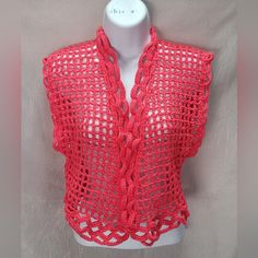 a red crocheted vest on a mannequin