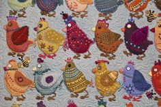 a group of small colorful birds sitting on top of a blue table cloth covered in crochet