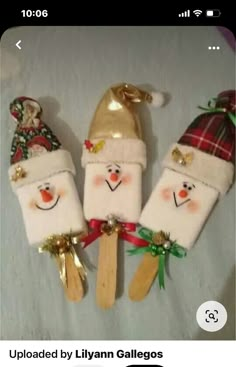 three snowmen made out of toothpicks with santa hats on them