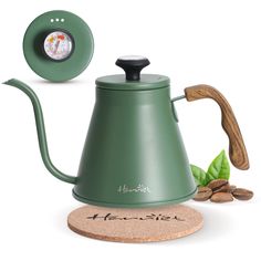 a green coffee pot with a wooden handle and lid on top of a cork coaster