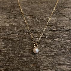 Dainty and minimal - gold filled necklace with a Swarovski pearl centre. Beautiful and elegant . Chain is adjustable Material : 14K gold filled Size : 5mm pearl Length : 16+2 inches Comes in a gift boxGold filled should NOT be confused with gold plating. It is an actual layer of solid gold, pressure bonded to another metal. Gold filled not only uses the double amount of gold , It’s also more valuable and tarnish resistant and does not flake or rub off. It's great for people that have skin sensit Delicate 14k Gold-filled Charm Necklace With Pearl Pendant, Delicate 14k Gold Filled Charm Necklaces With Pearl Pendant, Elegant Tiny Charm Necklaces In 14k Gold Filled, Dainty 14k Gold Filled Charm Necklace With Pearl Pendant, Minimalist Gold Charm Necklace With Pearl, Minimalist 14k Yellow Gold Filled Pearl Necklace, Dainty 14k Gold Pearl Necklace, Minimalist Pearl Pendant Necklace In 14k Gold, Minimalist 14k Gold-filled Pearl Pendant Necklace