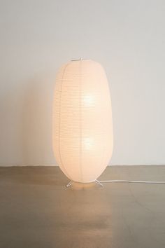 a white lamp sitting on top of a hard wood floor