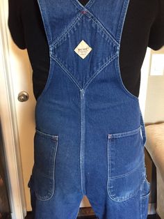 "Big Mac denim overalls in great condition, circa 1980. Medium wash blue. Very little wear overall, one bottom missing and stain shown. Durably made in the USA, classic vintage staple and statement piece. Inseam 30\" Inseam to top of bib 26\" Waist 36\"" Vintage Dark Wash Cotton Denim Jumpsuit, Vintage Denim Blue Overalls With Pockets, Retro Dark Wash Shortalls With Pockets, Vintage Denim Blue Jumpsuit With Pockets, Vintage Blue Shortalls, Vintage Medium Wash Washed Overalls, Vintage Denim Overalls In Medium Wash, Vintage Medium Wash Overalls With Pockets, Vintage Medium Wash Denim Overalls