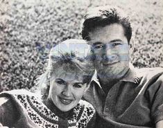 an old black and white photo of a man and woman posing for the camera with their arms around each other