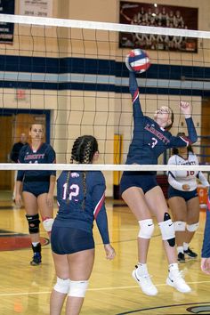 the volleyball players are trying to hit the ball