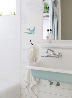 a bathroom with a sink, mirror and bathtub next to a shower curtain that has birds on it