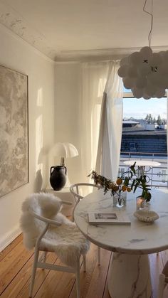 a dining room table with chairs and vases on it in front of a window