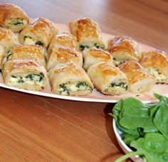 some food is sitting on a plate and next to a bowl of spinach leaves