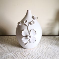 a white vase sitting on top of a table