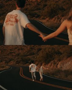 two people holding hands while walking down a road in the middle of an arid area