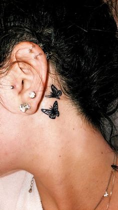 a woman with butterfly tattoos on her ear