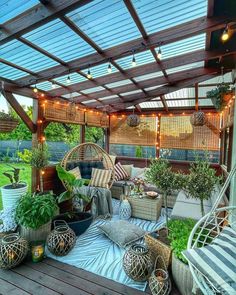 an outdoor patio with lots of plants and lights