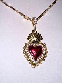 A beautiful 14k gold and red enamel sacred heart necklace on a 14k gold filled curb chain. Featuring cubic zirconia pave detailing on the pendant.Chain length: 17.5 Inch Gothic Vintage Jewelry, Luxury Vintage Red Necklaces, Sacred Heart Dangle Earrings, Luxury Antique Necklaces With Heart Charm, Red Jewel Necklace, Sacred Heart Earrings, Sacred Heart Jewelry, Mexican Gold Jewelry, Gold And Red Jewelry