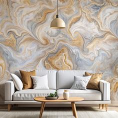 a white couch sitting in front of a wall covered in gold and blue marbles