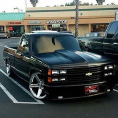 a black truck parked in front of a store