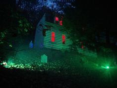 the house is lit up at night with green and red lights