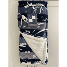 a blue and white dinosaur print blanket hanging on the wall next to a towel rack