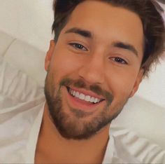 a man with a beard smiling for the camera
