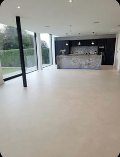 an empty kitchen and living room with large windows