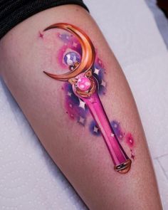 a woman's leg with a tattoo on it that has a pink pen and crescent