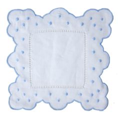 a white napkin with blue dots on the edges and a square shaped design in the middle