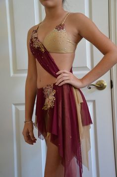 a woman in a red and gold costume posing for the camera with her hands on her hips