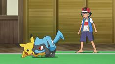 a young man standing next to a pikachu on top of a tennis court