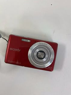 a red digital camera sitting on top of a white table