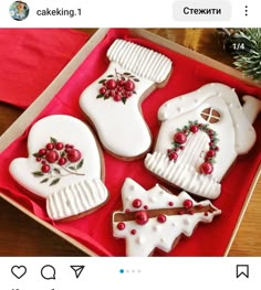 cookies decorated with icing and decorations in a box on top of a wooden table