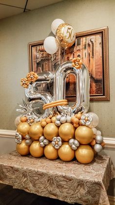 a table topped with balloons in the shape of numbers and gold, silver and white balls