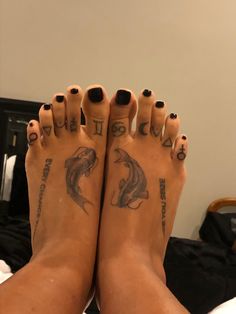 a person with black nail polish and tattoos on their feet